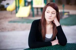 woman on playground considers finding a rehabilitation center