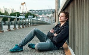man sitting against fence wonders about drug abuse statistics