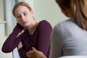 woman talks to therapist about recovery programs