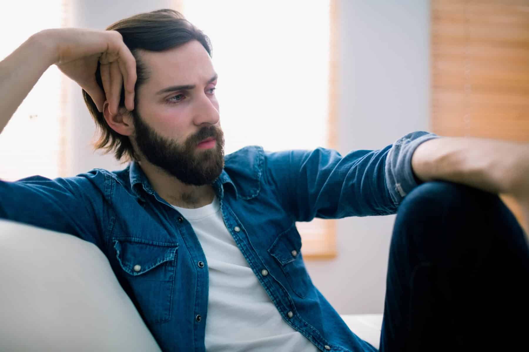 man thinking about the difference between alcohol and drug addiction