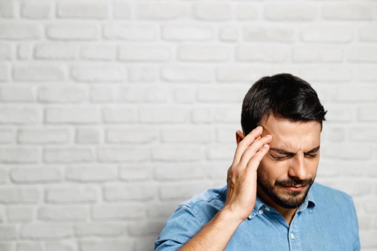 man putting his hand to his head stressed out