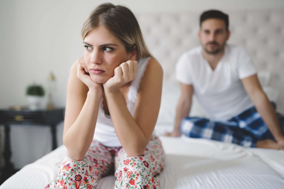 couple sitting on the bed because one of them is struggling with codependency