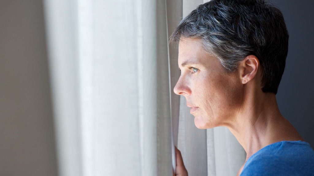 Portrait of older woman looking out window