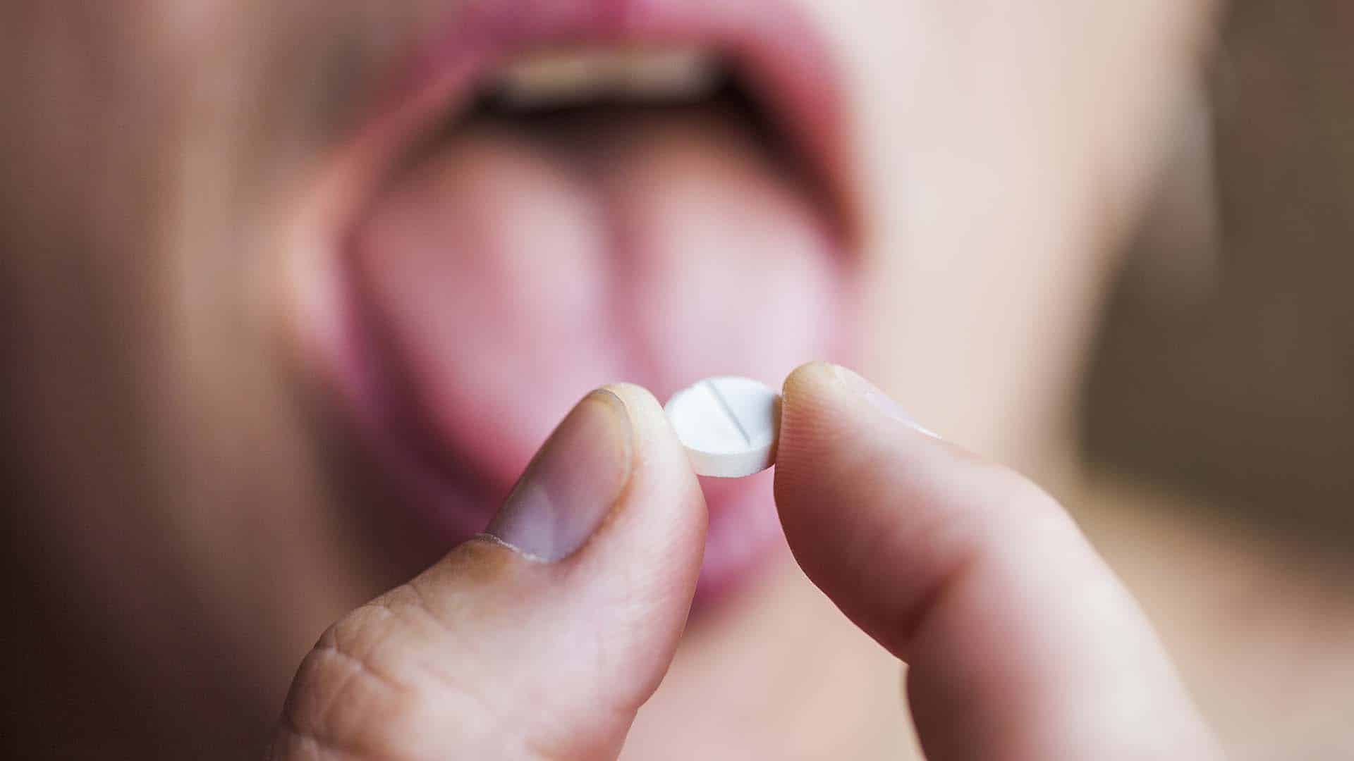 Close-up of man taking pill