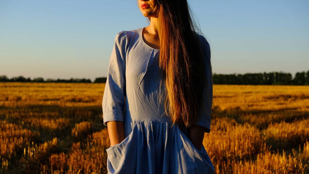beautiful female standing outside during golden hour in a field