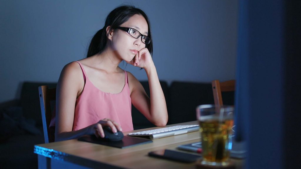 Woman feeling bored and looking at the computer