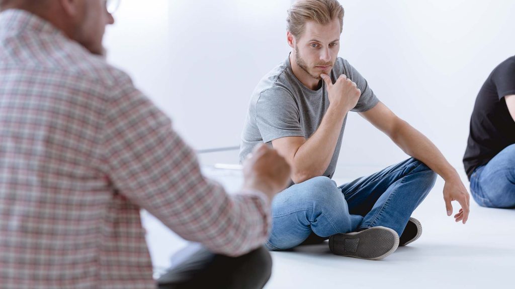 Young man and professional counselor during psychotherapy for people with ptsd